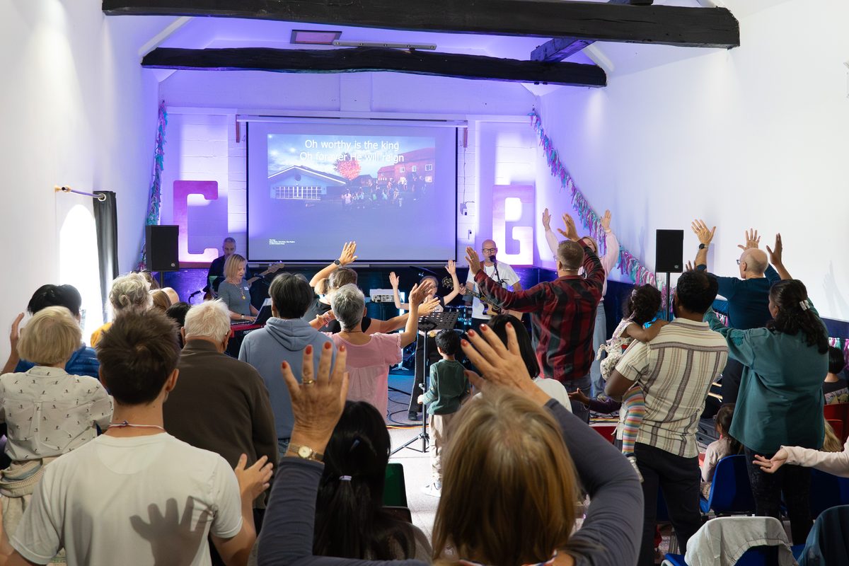 People of all ages worshipping with hands raised at the Connect Weekend Away